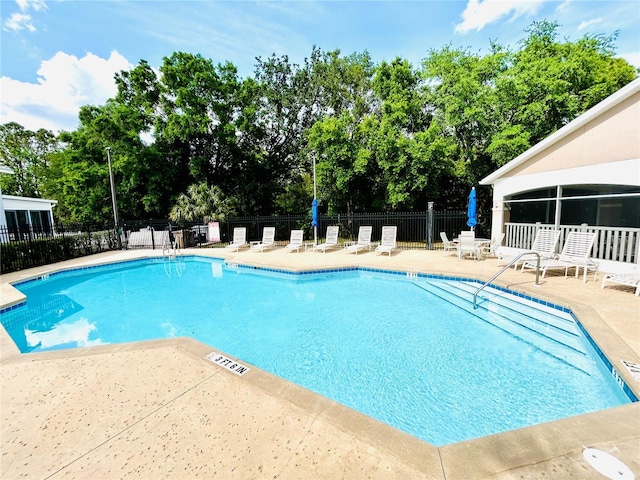 pool with fence and a patio