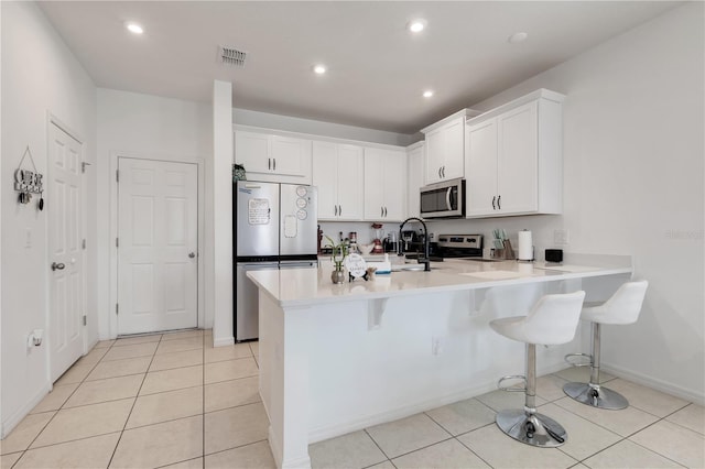 2412 Good Will Aly, Kissimmee, FL 34744 - kitchen with visible vents, light countertops, appliances with stainless steel finishes, a peninsula, and a breakfast bar area