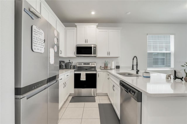 2412 Good Will Aly, Kissimmee, FL 34744 - kitchen featuring a peninsula, light countertops, light tile patterned flooring, stainless steel appliances, and a sink