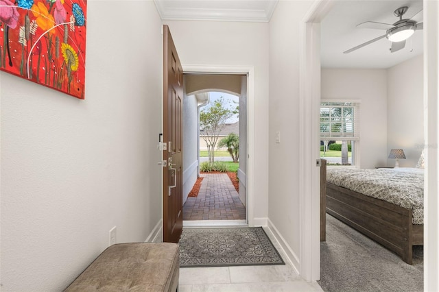 tiled foyer entrance featuring ornamental molding, baseboards, and a ceiling fan