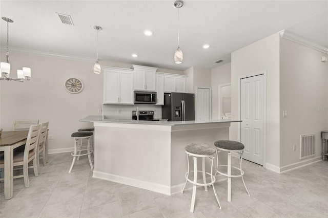 kitchen featuring stainless steel appliances, visible vents, a kitchen bar, and white cabinetry