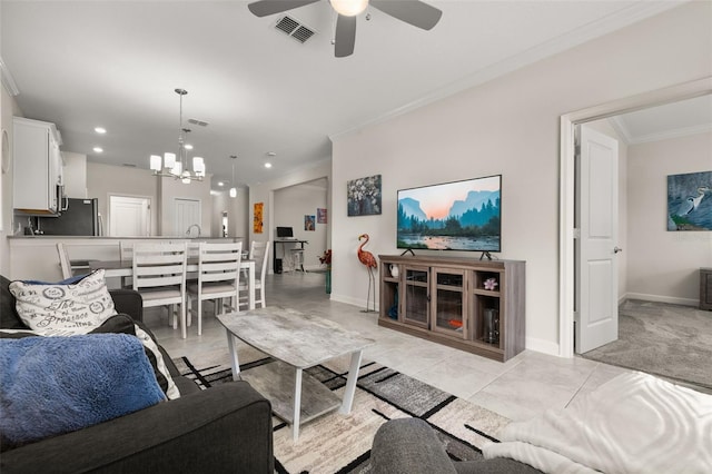 living area with crown molding, ceiling fan with notable chandelier, baseboards, and visible vents