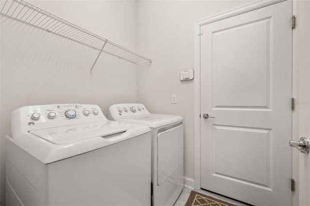 laundry area with independent washer and dryer, laundry area, and baseboards