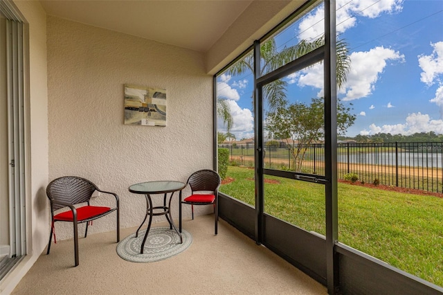 sunroom featuring a water view and a healthy amount of sunlight
