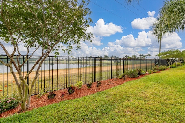 view of yard featuring a water view and fence