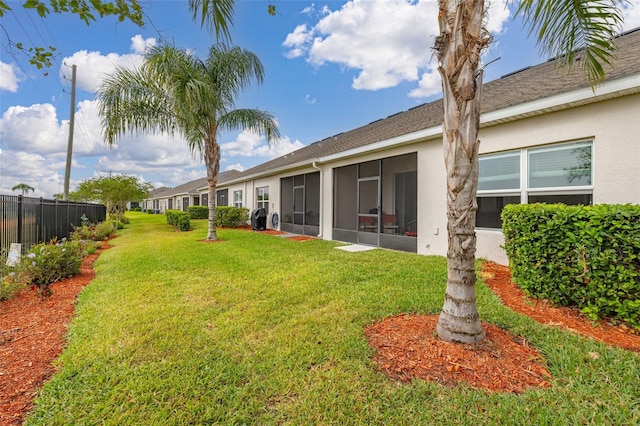 view of yard featuring a sunroom and fence