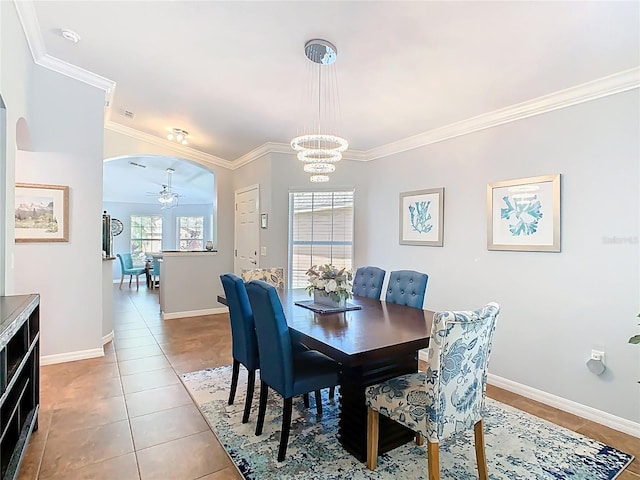 524 Grand Canal Dr, Poinciana, FL 34759 - tiled dining room with crown molding, baseboards, arched walkways, and ceiling fan with notable chandelier