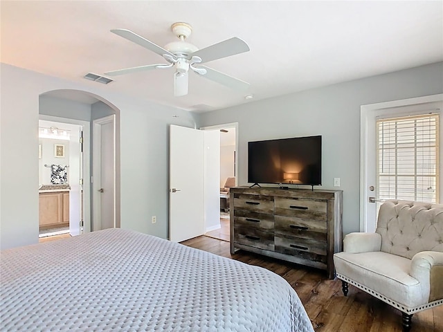 524 Grand Canal Dr, Poinciana, FL 34759 - bedroom featuring ensuite bath, visible vents, ceiling fan, arched walkways, and wood finished floors