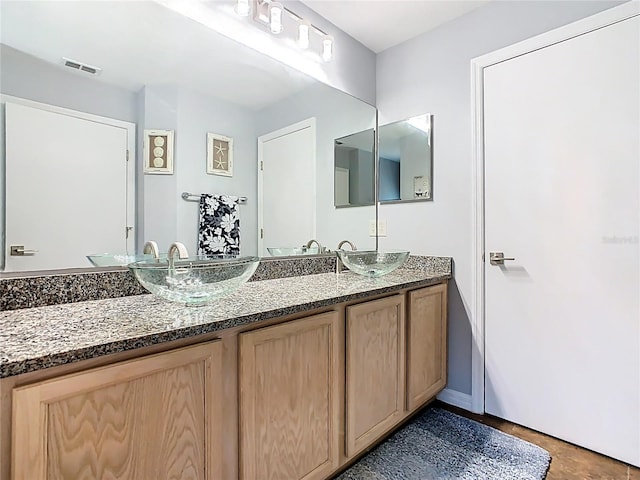 524 Grand Canal Dr, Poinciana, FL 34759 - full bathroom featuring double vanity, visible vents, baseboards, and a sink