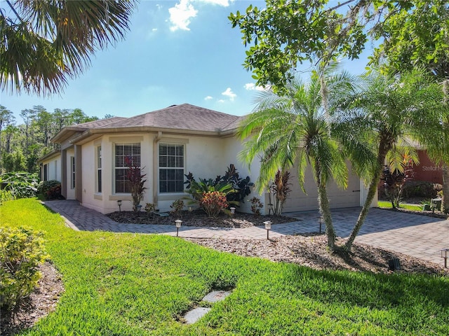 524 Grand Canal Dr, Poinciana, FL 34759 - view of front of property with a garage, a front yard, driveway, and stucco siding