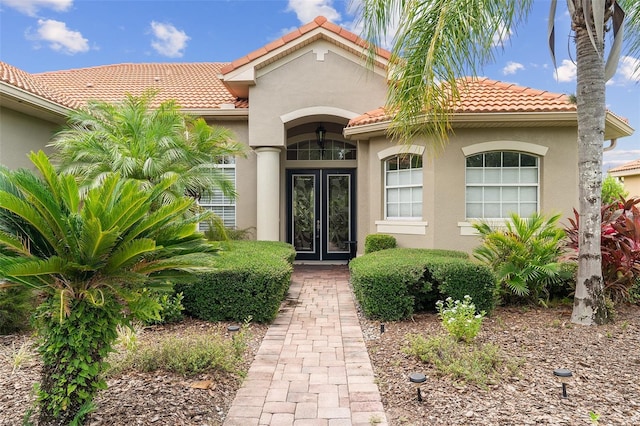 133 Torino Ln, Kissimmee, FL 34759 - doorway to property with french doors, a tile roof, and stucco siding