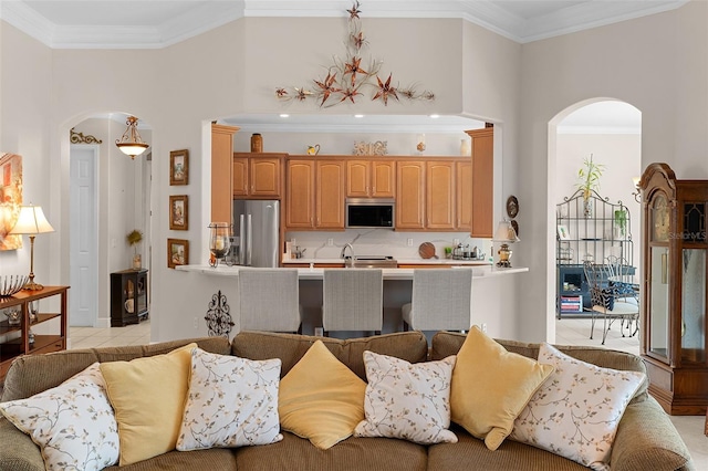 133 Torino Ln, Kissimmee, FL 34759 - living area featuring arched walkways, light tile patterned floors, and crown molding