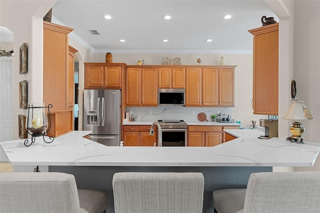 133 Torino Ln, Kissimmee, FL 34759 - kitchen featuring stainless steel appliances, a peninsula, ornamental molding, recessed lighting, and a breakfast bar