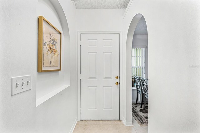 1560 Vista Lake Cir, Melbourne, FL 32904 - entrance foyer featuring light tile patterned floors, arched walkways, and a textured ceiling