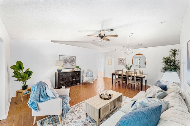 1560 Vista Lake Cir, Melbourne, FL 32904 - living room with arched walkways, a textured ceiling, a ceiling fan, wood finished floors, and lofted ceiling