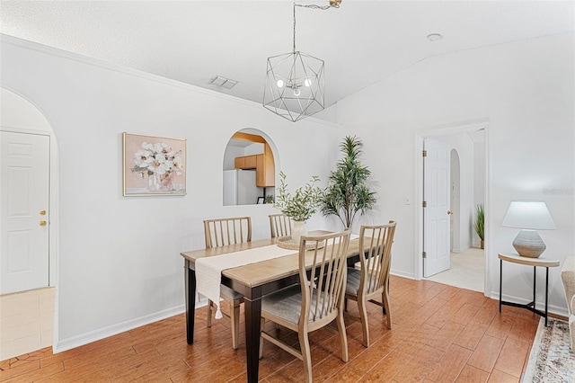 1560 Vista Lake Cir, Melbourne, FL 32904 - dining space featuring arched walkways, an inviting chandelier, visible vents, and light wood-style floors
