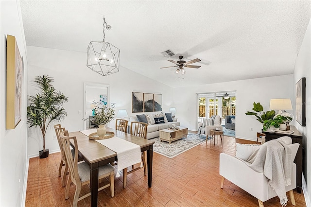 1560 Vista Lake Cir, Melbourne, FL 32904 - dining space with visible vents, light wood-style flooring, a textured ceiling, and ceiling fan with notable chandelier