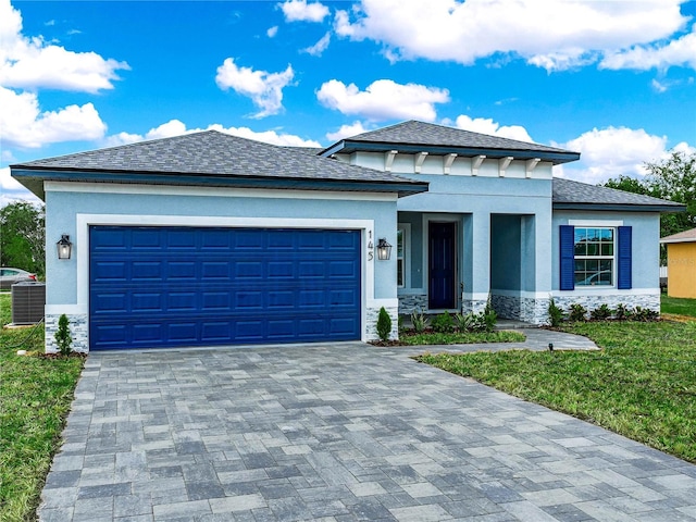 145 Willow Dr, Poinciana, FL 34759 - prairie-style home featuring stucco siding, stone siding, decorative driveway, and an attached garage