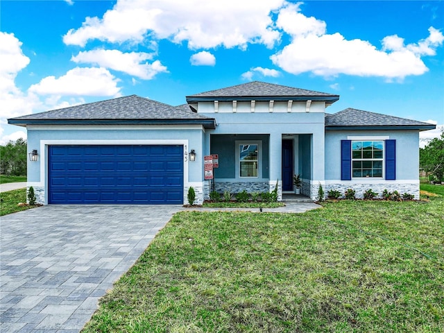 145 Willow Dr, Poinciana, FL 34759 - prairie-style home with stucco siding, decorative driveway, stone siding, a front lawn, and an attached garage