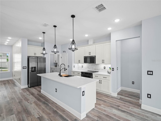 145 Willow Dr, Poinciana, FL 34759 - kitchen featuring visible vents, a sink, black appliances, and backsplash