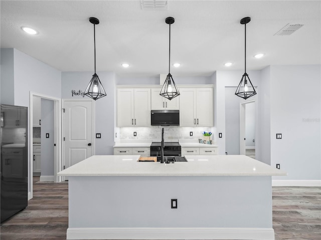 145 Willow Dr, Poinciana, FL 34759 - kitchen featuring a sink, visible vents, tasteful backsplash, and wood finished floors