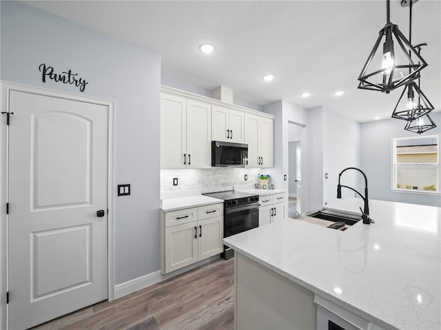 145 Willow Dr, Poinciana, FL 34759 - kitchen featuring a sink, white cabinets, electric range, and light stone counters