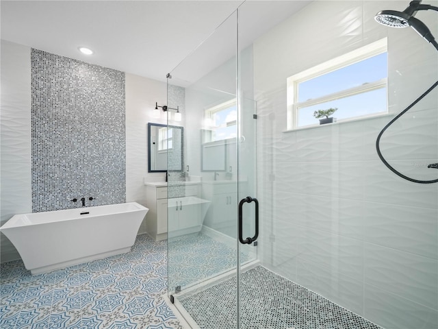 145 Willow Dr, Poinciana, FL 34759 - full bath with a freestanding bath, tile walls, vanity, tile patterned flooring, and a stall shower