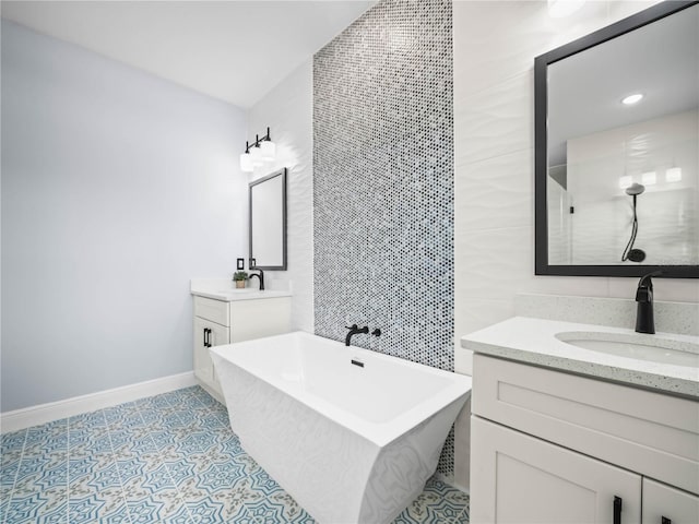 145 Willow Dr, Poinciana, FL 34759 - full bathroom featuring two vanities, baseboards, a sink, and a freestanding tub