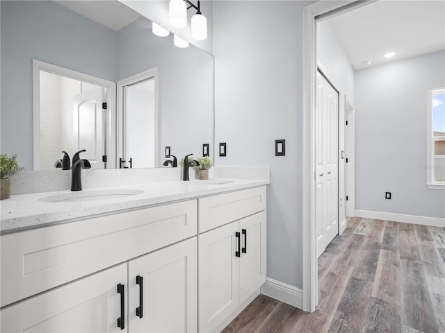 145 Willow Dr, Poinciana, FL 34759 - full bath with a sink, baseboards, double vanity, and wood finished floors