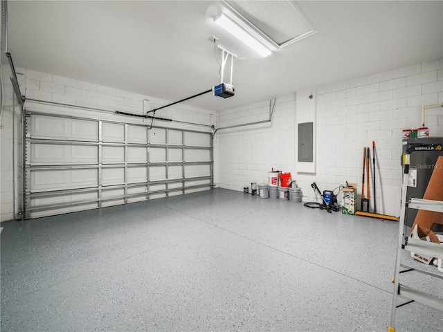 145 Willow Dr, Poinciana, FL 34759 - garage featuring concrete block wall, gas water heater, a garage door opener, and electric panel