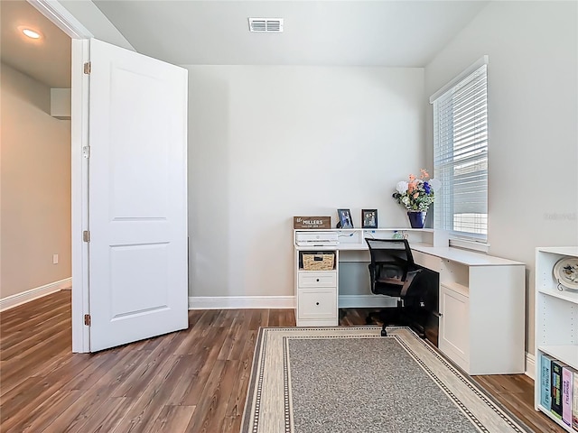 office area with baseboards, visible vents, built in desk, and dark wood-style flooring