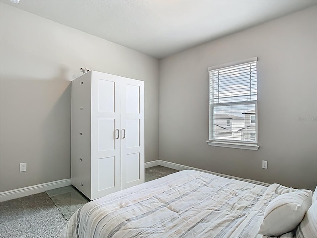 bedroom featuring baseboards and a closet