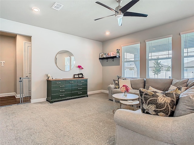 living room with ceiling fan, baseboards, carpet flooring, and visible vents