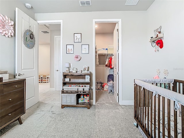 carpeted bedroom with baseboards, visible vents, a closet, and a walk in closet