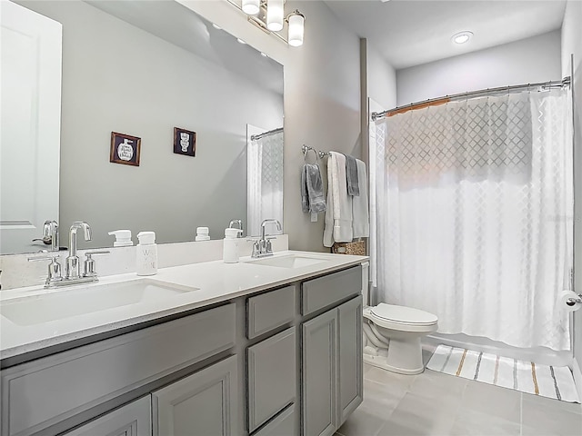 bathroom featuring double vanity, toilet, shower / bath combo, and a sink