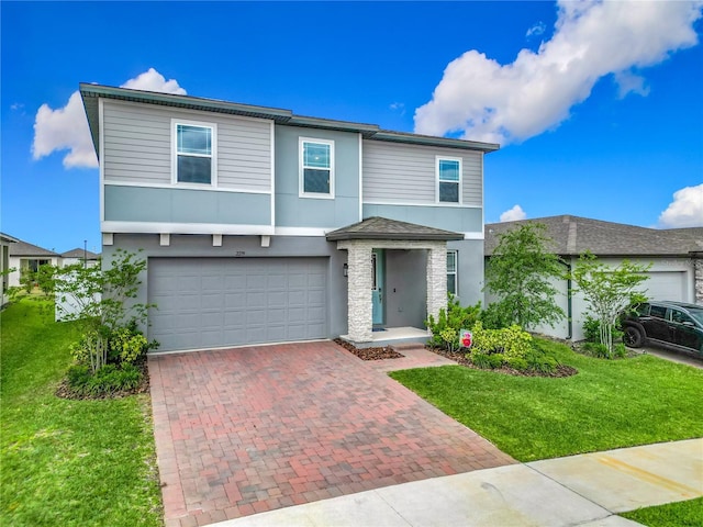 traditional-style house with a garage, a front lawn, stucco siding, and decorative driveway
