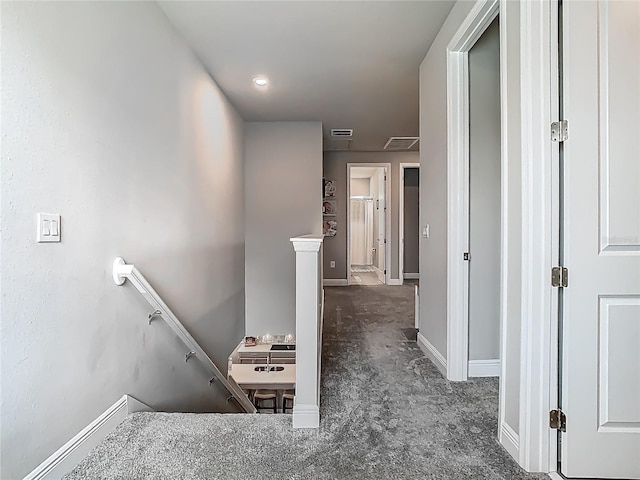 hallway with baseboards, an upstairs landing, visible vents, and carpet