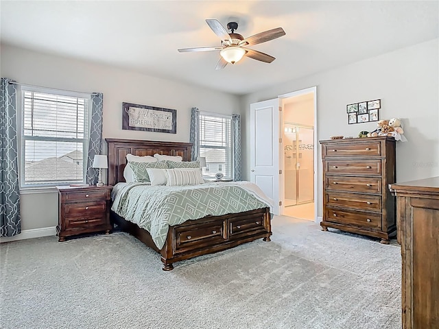 bedroom featuring carpet, baseboards, ceiling fan, and ensuite bathroom