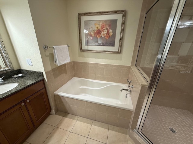 full bathroom featuring tile patterned floors, a bath, a stall shower, and vanity