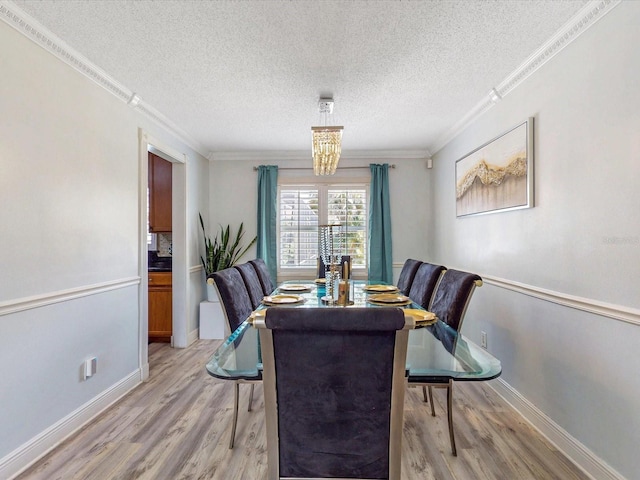 5123 Lighthouse Rd, Orlando, FL 32808 - dining room with light wood finished floors, ornamental molding, a textured ceiling, and baseboards