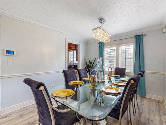 5123 Lighthouse Rd, Orlando, FL 32808 - dining area featuring a textured ceiling, light wood-style flooring, crown molding, baseboards, and a chandelier