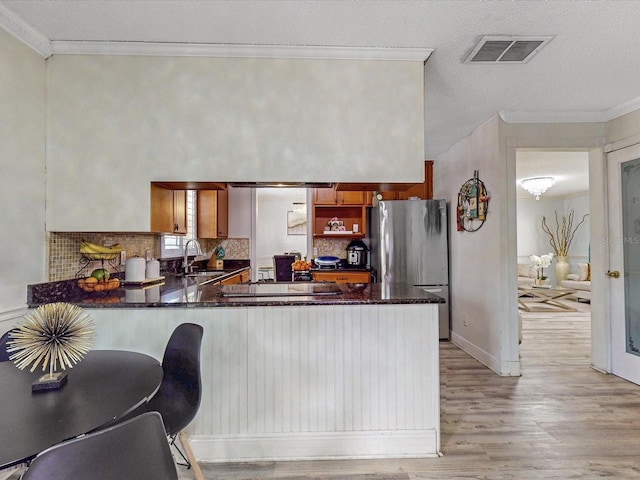 5123 Lighthouse Rd, Orlando, FL 32808 - kitchen with freestanding refrigerator, light wood finished floors, crown molding, a peninsula, and a sink