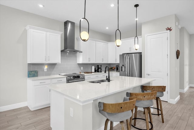 8338 Modiano St, Orlando, FL 32827 - kitchen featuring baseboards, wall chimney exhaust hood, a sink, light wood-style flooring, and appliances with stainless steel finishes