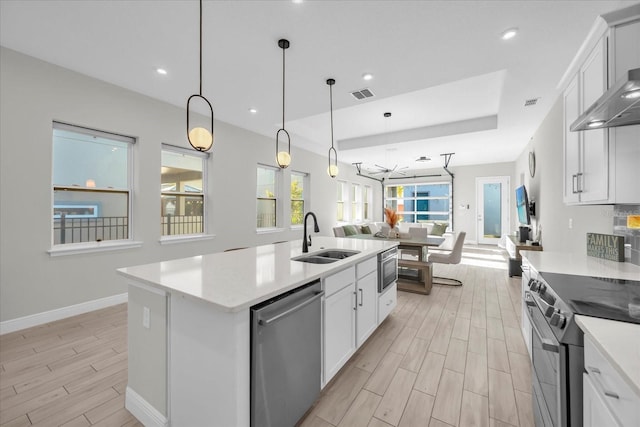 8338 Modiano St, Orlando, FL 32827 - kitchen featuring visible vents, open floor plan, wood tiled floor, a sink, and appliances with stainless steel finishes