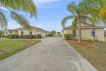 18011 Prairie Wolf Gln, Parrish, FL 34219 - view of front of property with a garage, stucco siding, driveway, and a front yard