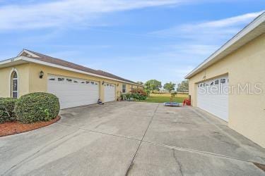 18011 Prairie Wolf Gln, Parrish, FL 34219 - view of home's exterior featuring a garage, stucco siding, and driveway