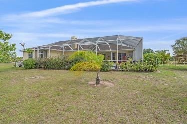 18011 Prairie Wolf Gln, Parrish, FL 34219 - rear view of property with glass enclosure and a yard