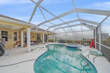 18011 Prairie Wolf Gln, Parrish, FL 34219 - view of swimming pool featuring glass enclosure, a pool with connected hot tub, and a patio area