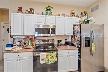 18011 Prairie Wolf Gln, Parrish, FL 34219 - kitchen featuring visible vents, light countertops, appliances with stainless steel finishes, and white cabinets