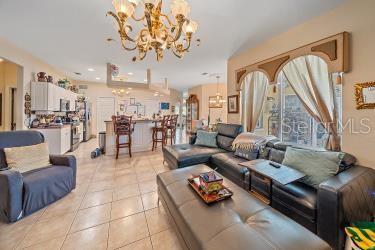18011 Prairie Wolf Gln, Parrish, FL 34219 - living room featuring a notable chandelier and light tile patterned floors